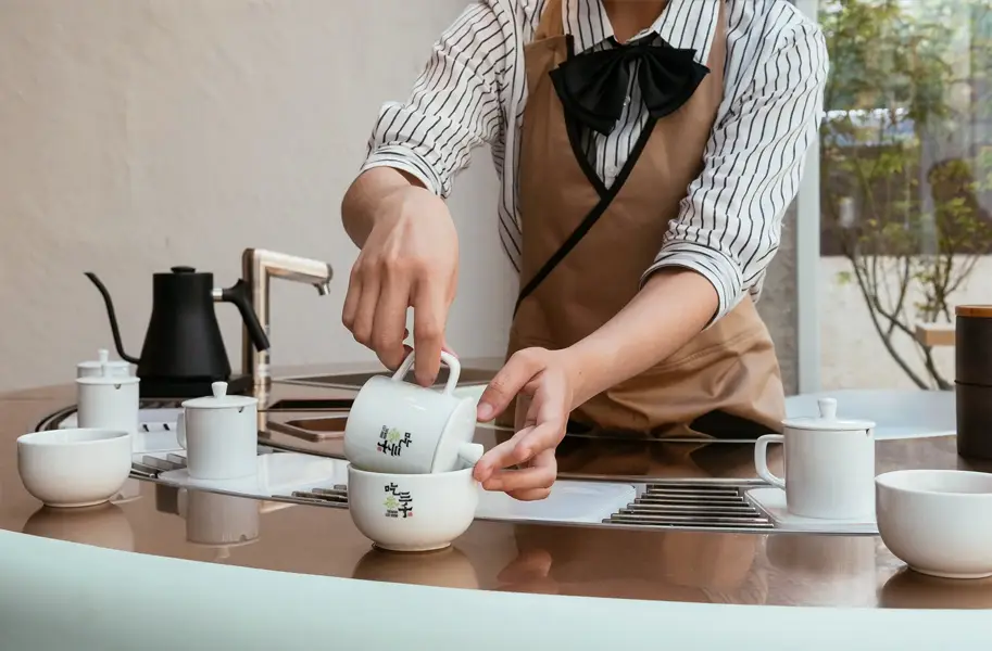 A Chi Cha San Chen server pouring tea at the tasting bar